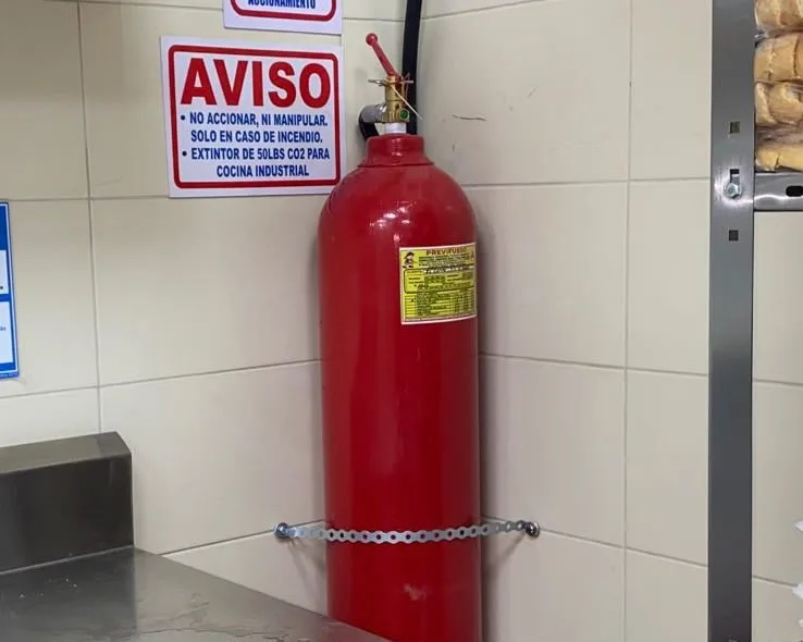 Extintor CO₂ 50 lbs señalizado para cocina industrial